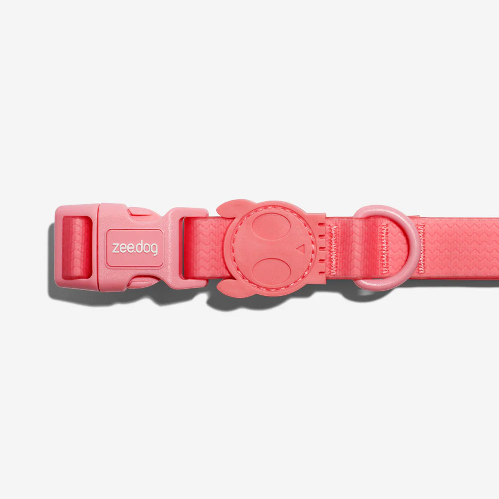 A vibrant pink dog collar featuring a snap buckle and a playful smiley face design on the adjuster. Perfect for stylish pets.