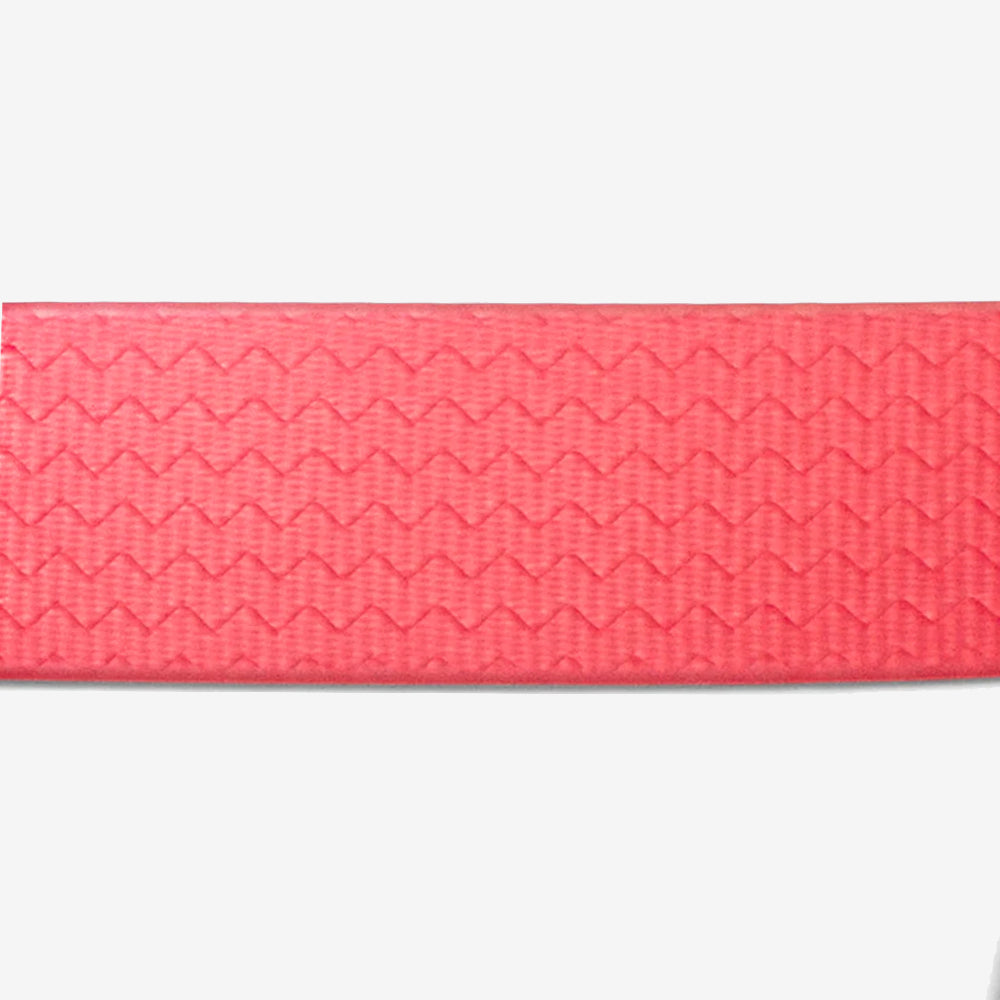 Close-up of a textured, coral pink ribbon featuring a zigzag pattern, set against a white background.