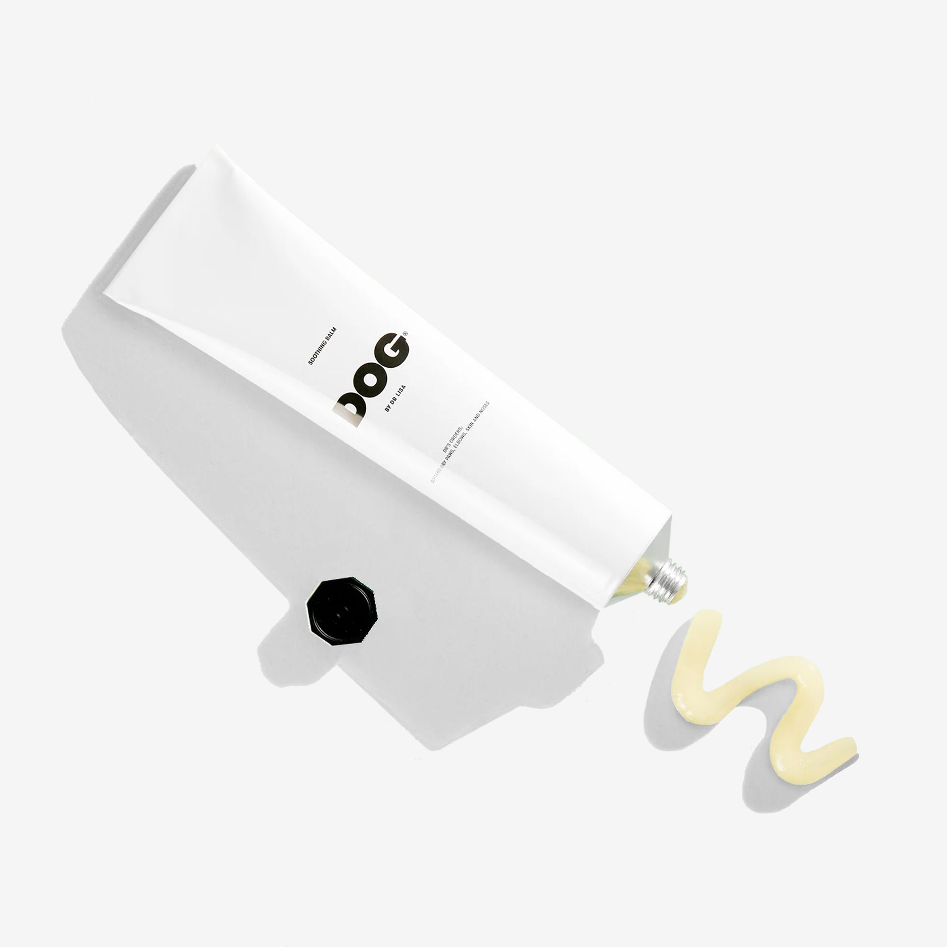 a white aluminium tube filled with a coat masque for dogs from above with cream coming out