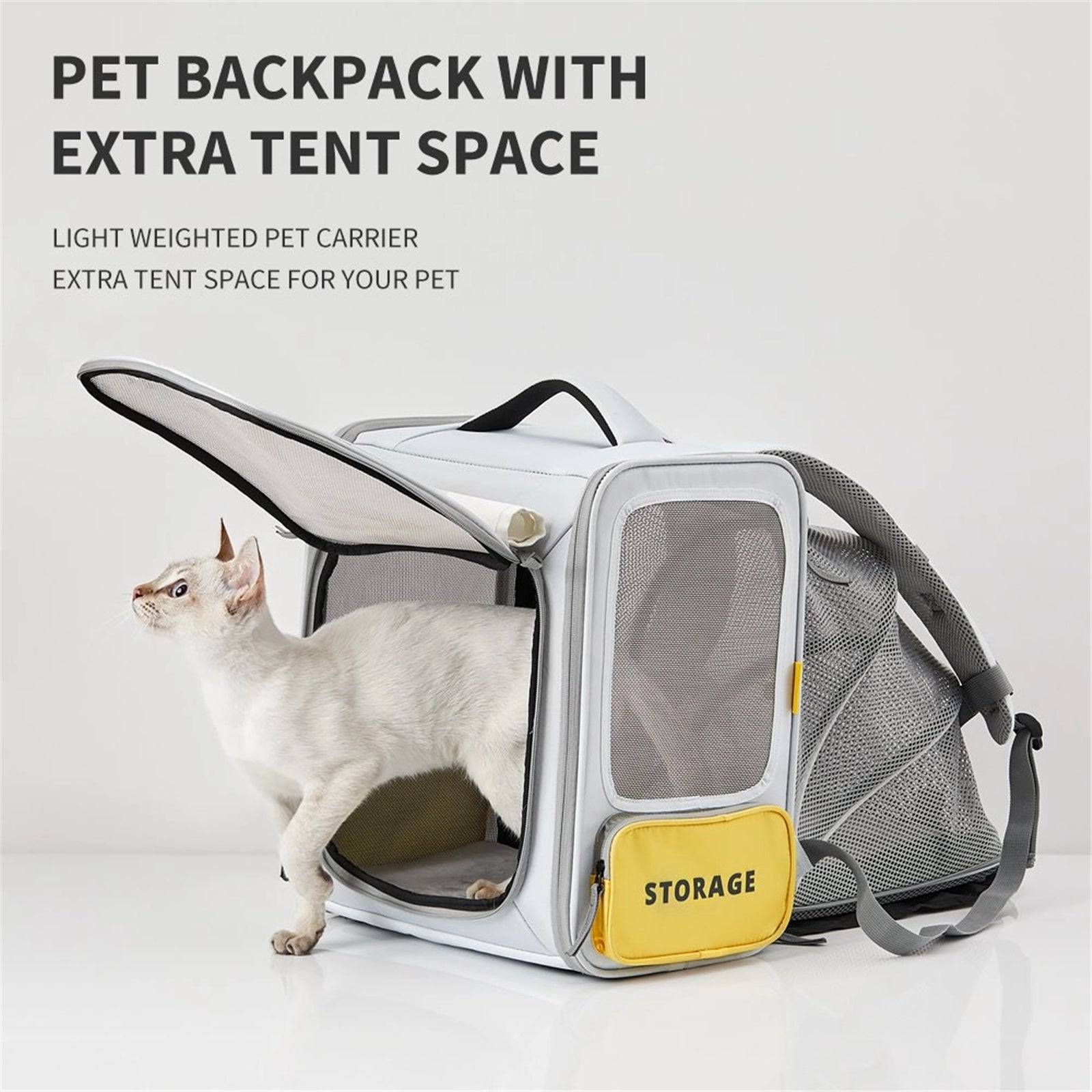 A white cat stepping out from a grey pet backpack by PetKit with extra tent space, featuring a yellow storage compartment on the side.