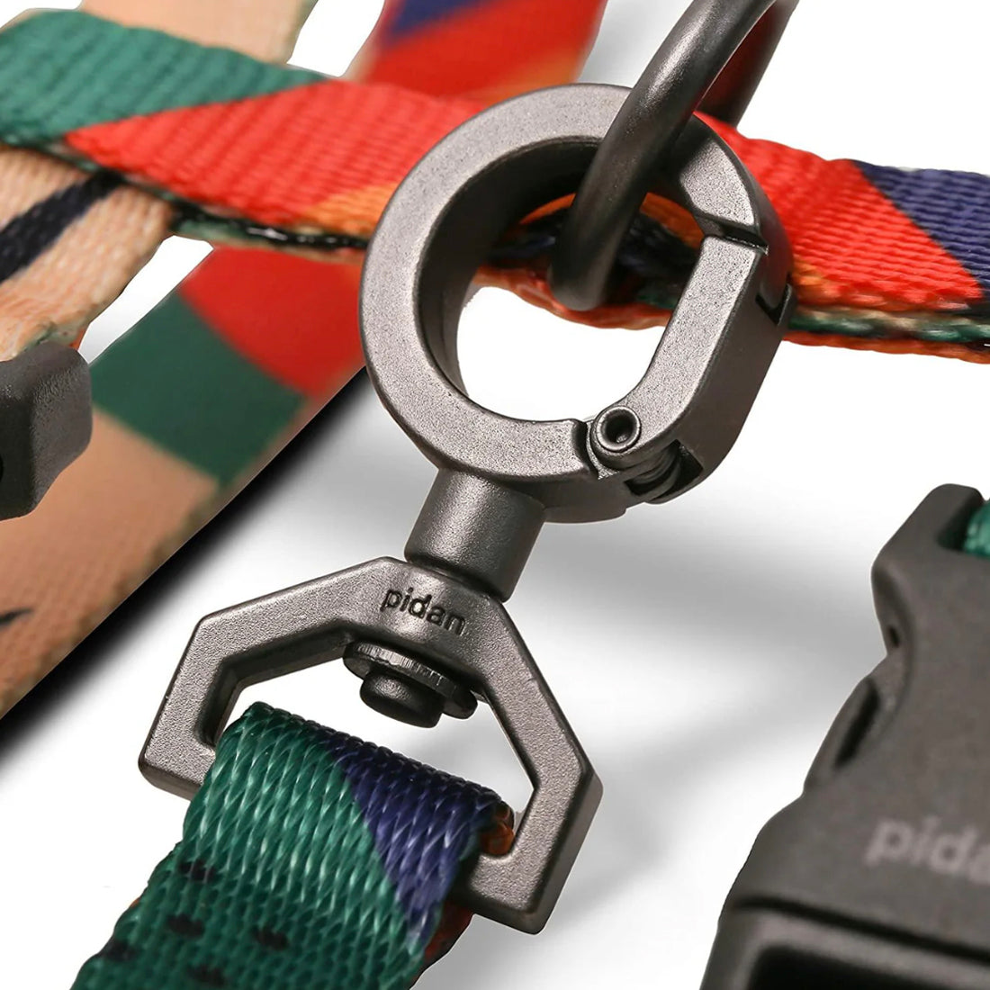 Close-up of a silver-colored metal carabiner on a cat harness and leash set with the brand name "pidan" engraved on it, attached to a colorful woven strap.