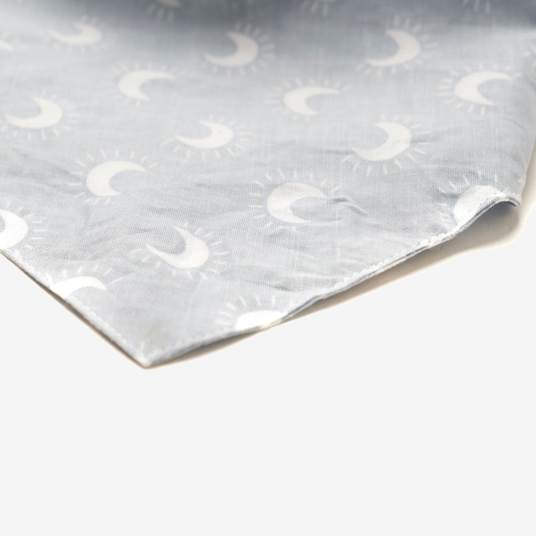 Close up fabric thats pale blue dog bandana featuring white crescent moons