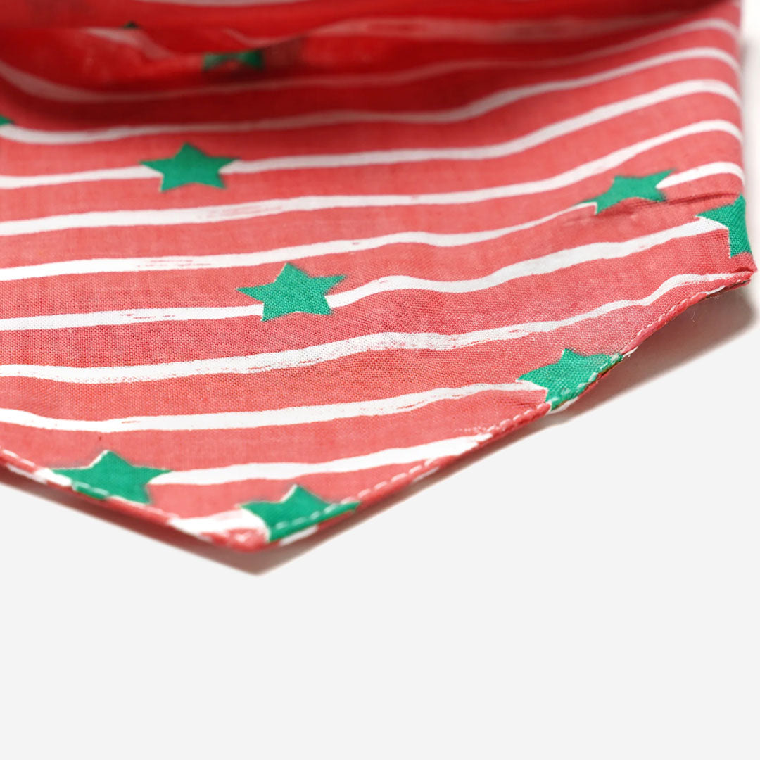 close up of a 100% cotton dog bandana with green stars on a red and white striped fabric