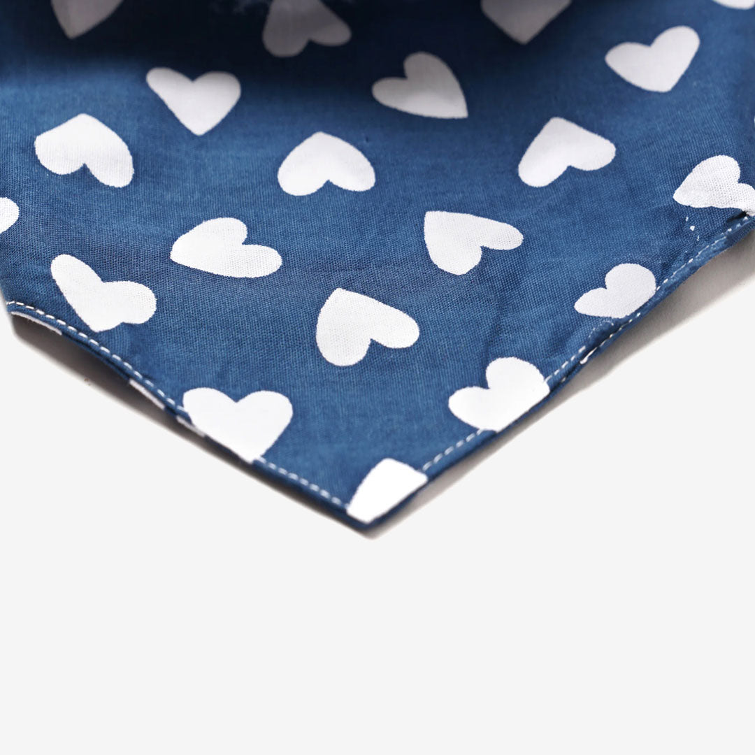 Close up fabric of a 100% cotton dog bandana in navy blue patterned with white hearts