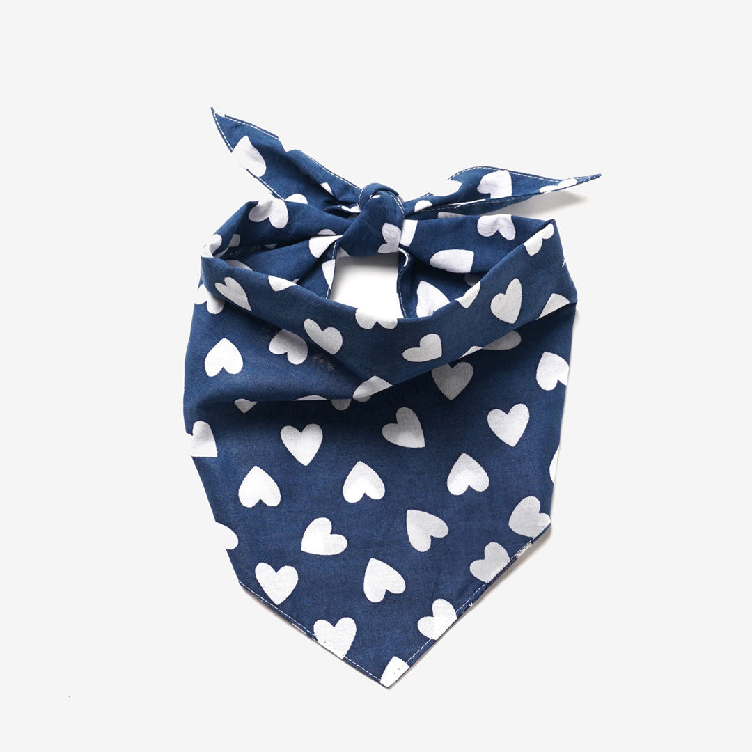 A100% cotton dog bandana in navy blue patterned with white hearts