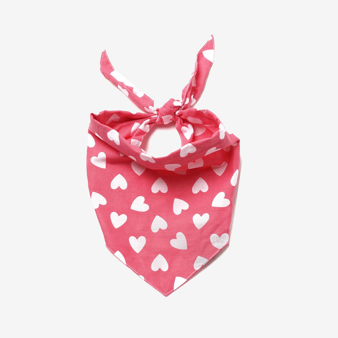 A 100% pink cotton dog bandana patterned with white hearts