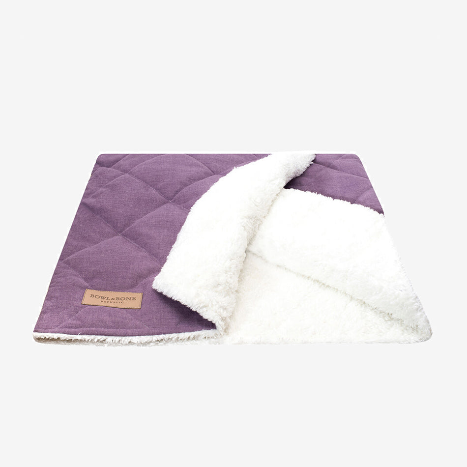 A purple dog blanket/sleeping bag quilted fully and fully lined with a cream fluffy inner