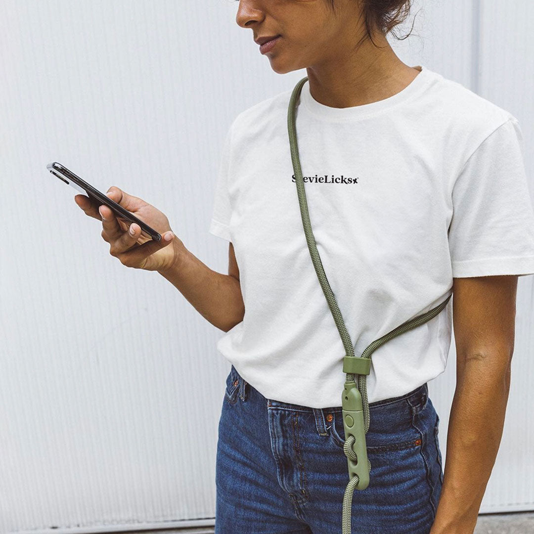 Lady wearing a stevie licks tee and a army green hands free leash around her shoulder