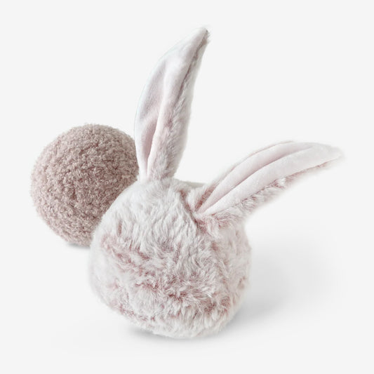 A plush pale bunny shaped ball with two bynny ears, sat next to a plush ball dog toy.