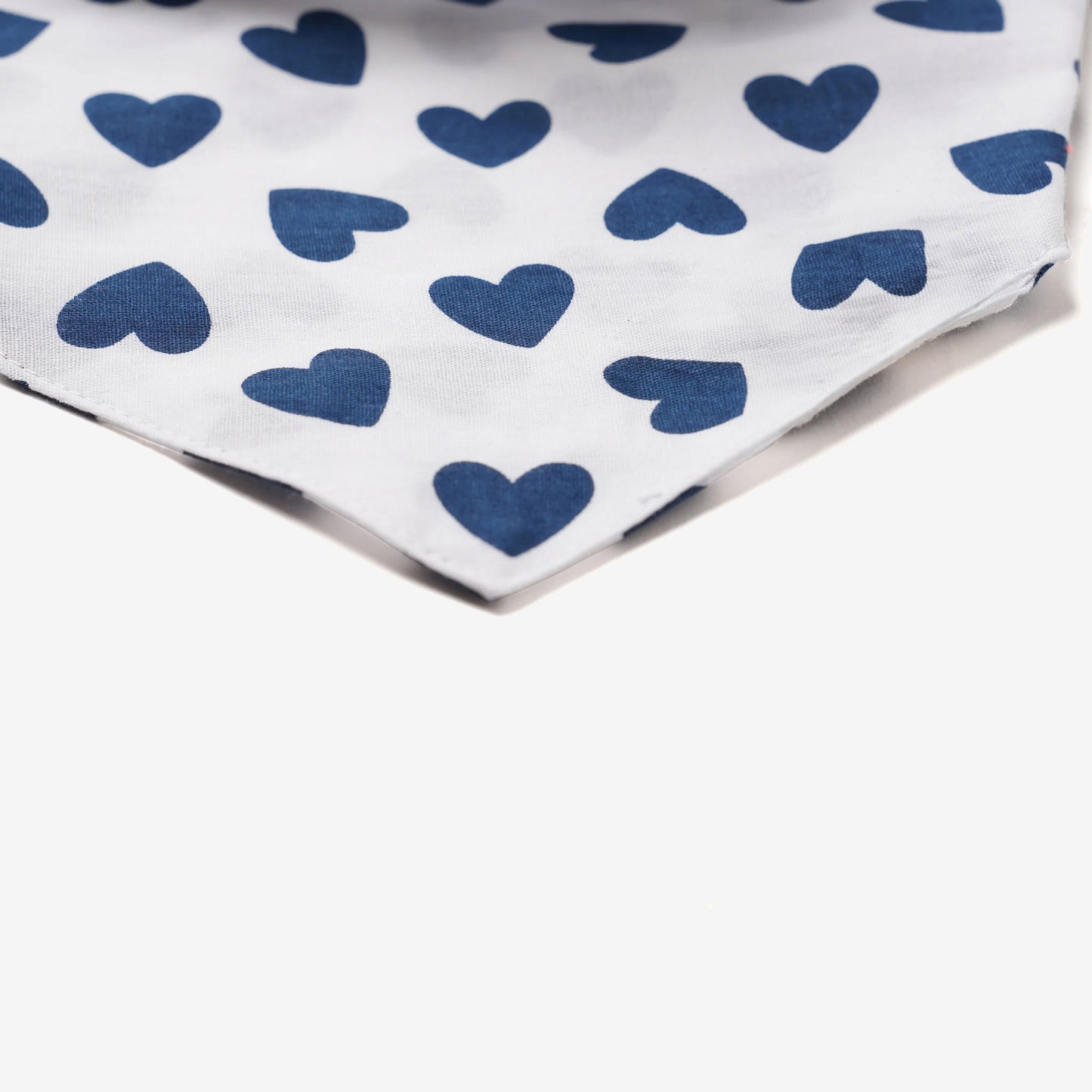 Close up fabric of a dog bandana with navy Blue hearts on white 