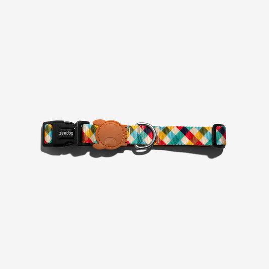 Colourful geometric-patterned dog collar with a black buckle and leather tag, featured against a white background.