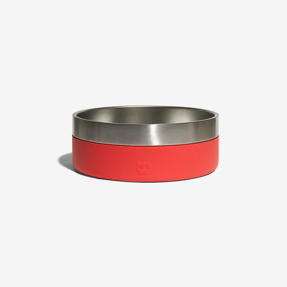 A stainless steel dog bowl with a red rubber exterior by Zee Dog resting against a plain white background.