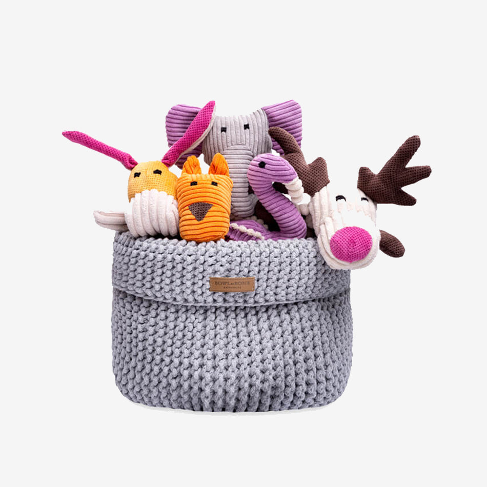 a grey toy basket filled with plush dog toys