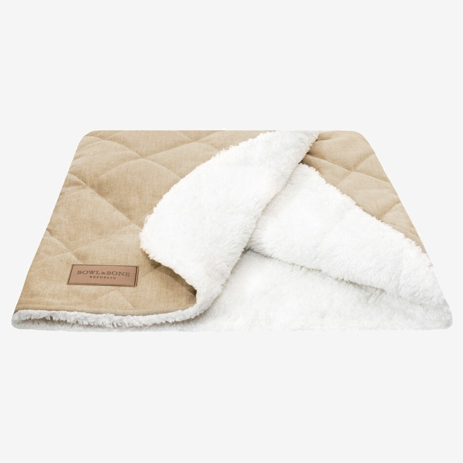 A beige dog blanket/sleeping bag quilted fully and fully lined with a cream fluffy inner