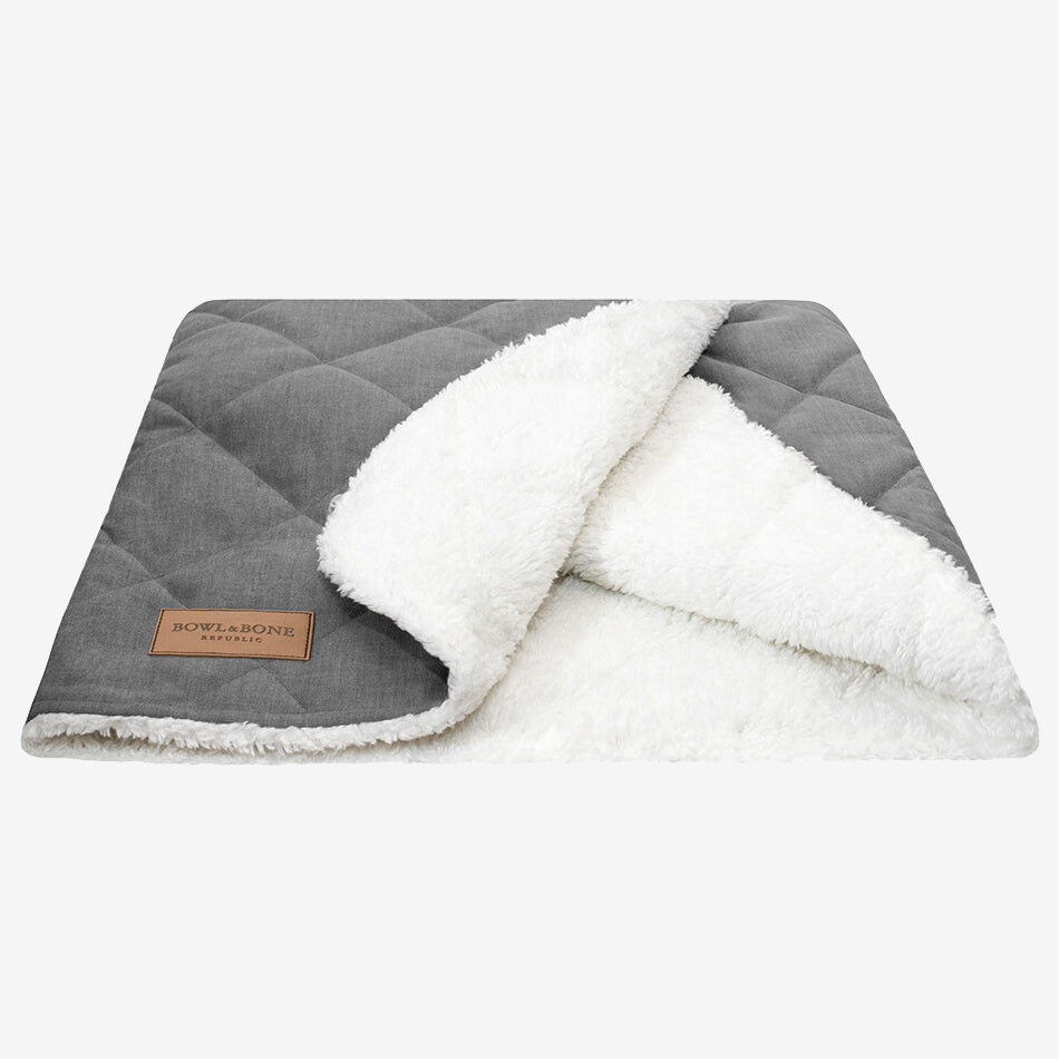 A grey dog blanket/sleeping bag quilted fully and fully lined with a cream fluffy inner