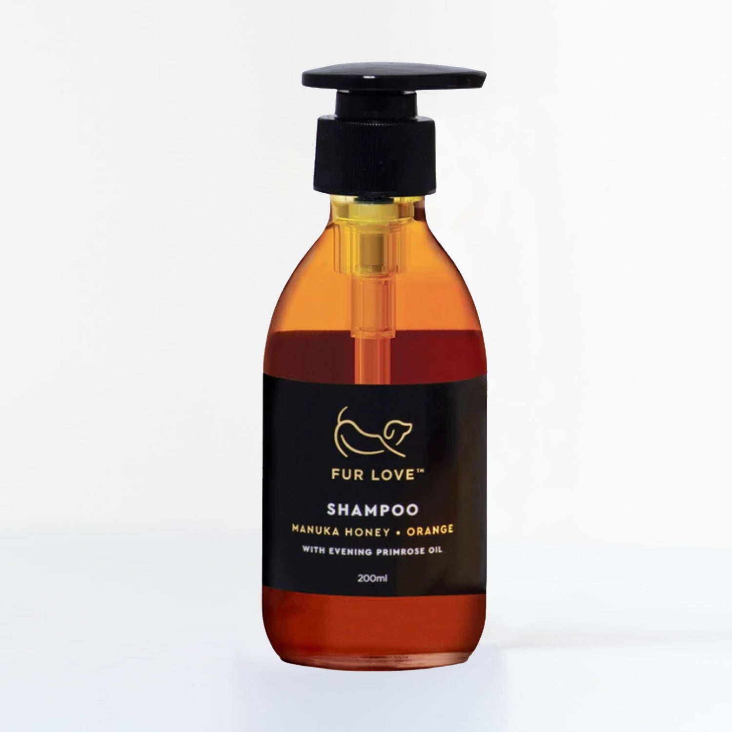 A clear brown bottle with a black pump, filled with manuka honey and orange dog shampoo.